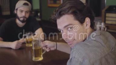 两个男人坐在酒吧里<strong>一起</strong>喝啤酒。<strong>大家一起</strong>喝啤酒玩得很开心。一个人看着